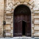 Ci spostiamo infine davanti all�ingresso costituito da un ampio portone in legno circoscritto in un portale ad arco centinato con paraste e doppia fascia di bugne